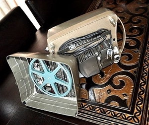 Cavalier De Luxe 8mm vintage movie projector with metal case and blue film reel Cavalier De Luxe 8mm vintage movie projector with metal case and blue film reel