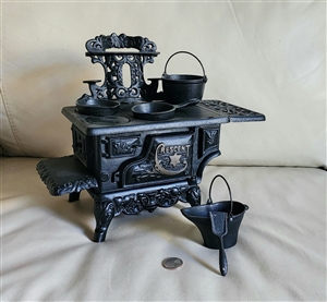 Preowned vintage Crescent cast iron salesman sample stove decorative display with miniature accessories front view Preowned vintage Crescent cast iron salesman sample stove decorative display with miniature accessories front view