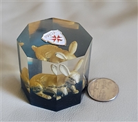 Hexagonal clear Lucite paperweight encasing a golden rabbit figurine with blue base layer and Maltese Cross emblem on top Hexagonal clear Lucite paperweight encasing a golden rabbit figurine with blue base layer and Maltese Cross emblem on top